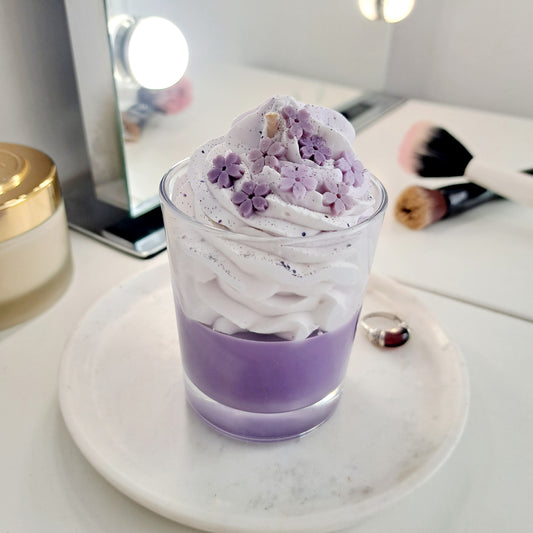 Bougie senteur lilas au vrai parfum de grasse faite à la main en France. Cette bougie à l'apparence gourmande est décorée d'une chantilly réhaussée de fleurs couleur parme avec un fini pailleté !